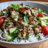 This Pesto Chicken Bowl blends juicy chicken, tomatoes, cucumber, and pine nuts for a colorful, nutritious dinner.