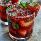 Vibrant citrus and white grape sangria mocktail with fresh fruit and sparkling water, ideal for warm weather.  