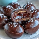 Creamy peanut butter filling coated in rich dark chocolate, finished with a touch of flaky sea salt for a sweet-savory delight.