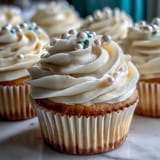 Delicate Cancer birthday cupcakes adorned with elegant fondant pearls and fluffy frosting.