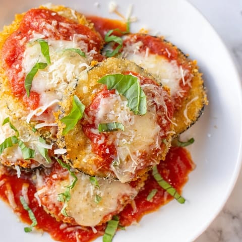 A close-up of Eggplant Parmesan shows the layers of cheese, sauce, and tender eggplant.