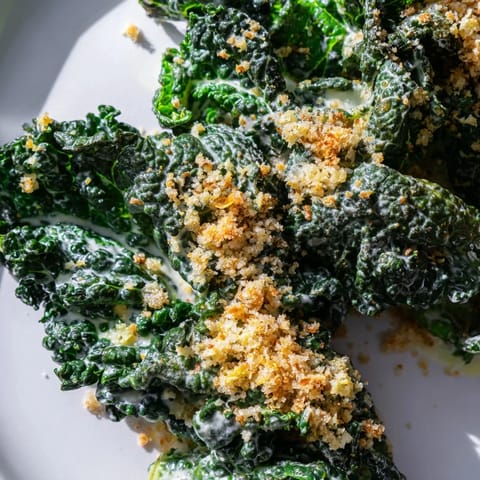 Freshly prepared Garlic Parmesan Kale Salad tossed in a creamy dressing, topped with crispy panko breadcrumbs and shaved Parmesan, perfect as a light lunch or side.