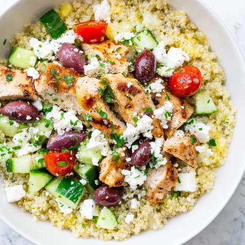 Colorful Mediterranean Chicken Bowl with grilled chicken, quinoa, chickpeas, olives, feta, and crisp veggies, drizzled with a zesty lemon-oregano dressing.