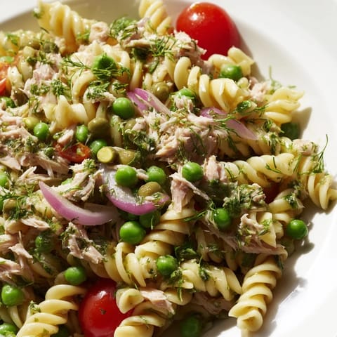 Cool and satisfying lemony tuna pasta salad tossed with crisp red onion, parsley, and dill, perfect for summer picnics.