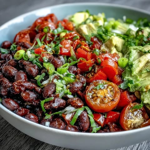 Colorful plant-based taco bowl ready to be topped with creamy avocado and salsa.