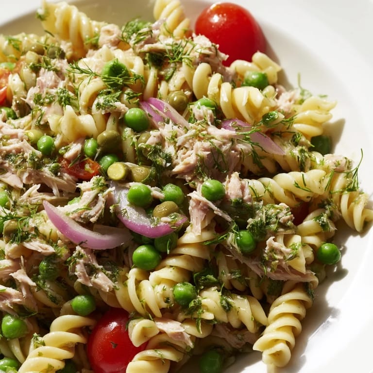 Cool and satisfying lemony tuna pasta salad tossed with crisp red onion, parsley, and dill, perfect for summer picnics.