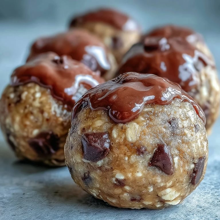 These no-bake Banana Chocolate Chip Energy Balls are ready to eat, showcasing a rustic texture with visible banana flecks and chocolate chunks.  