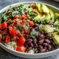 Vibrant plant-based taco bowl overflowing with seasoned black beans and fresh salsa.